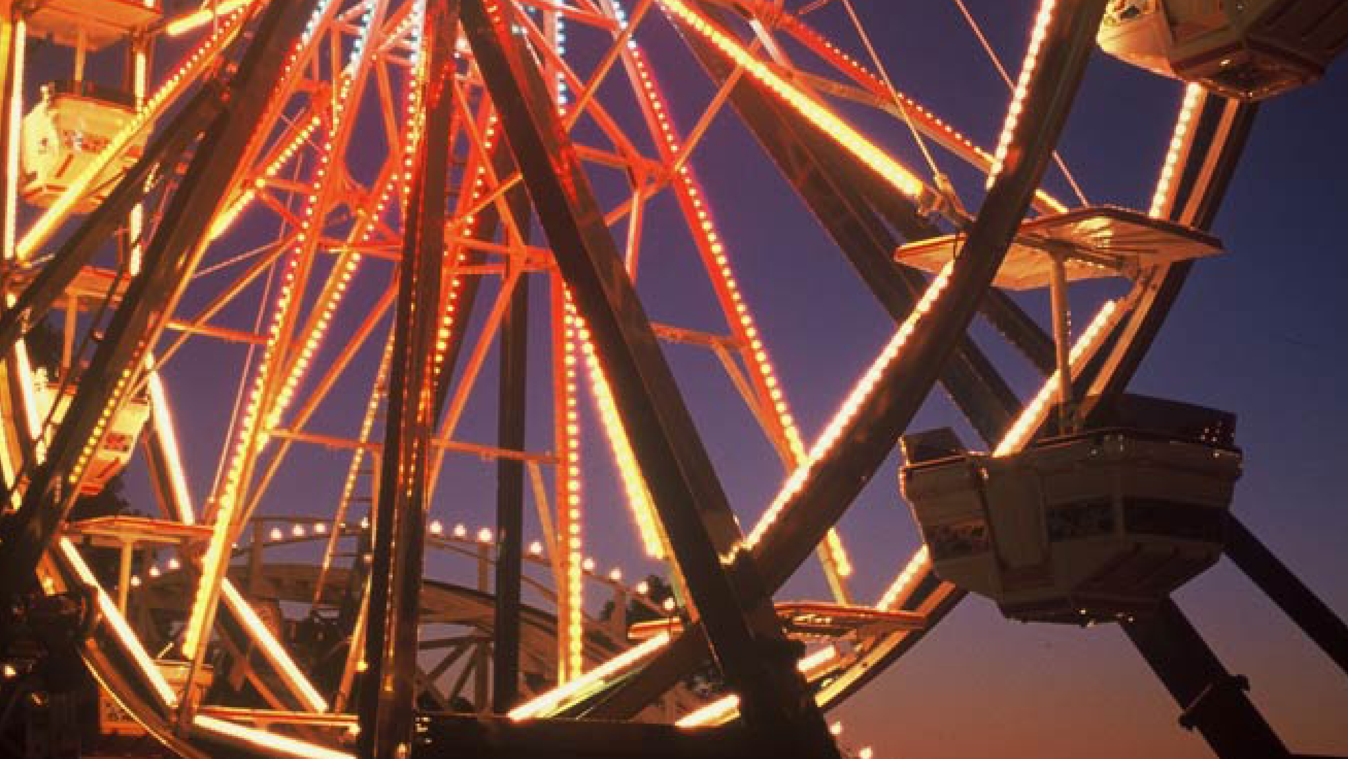 A young girl riding a tiger on the carousel.